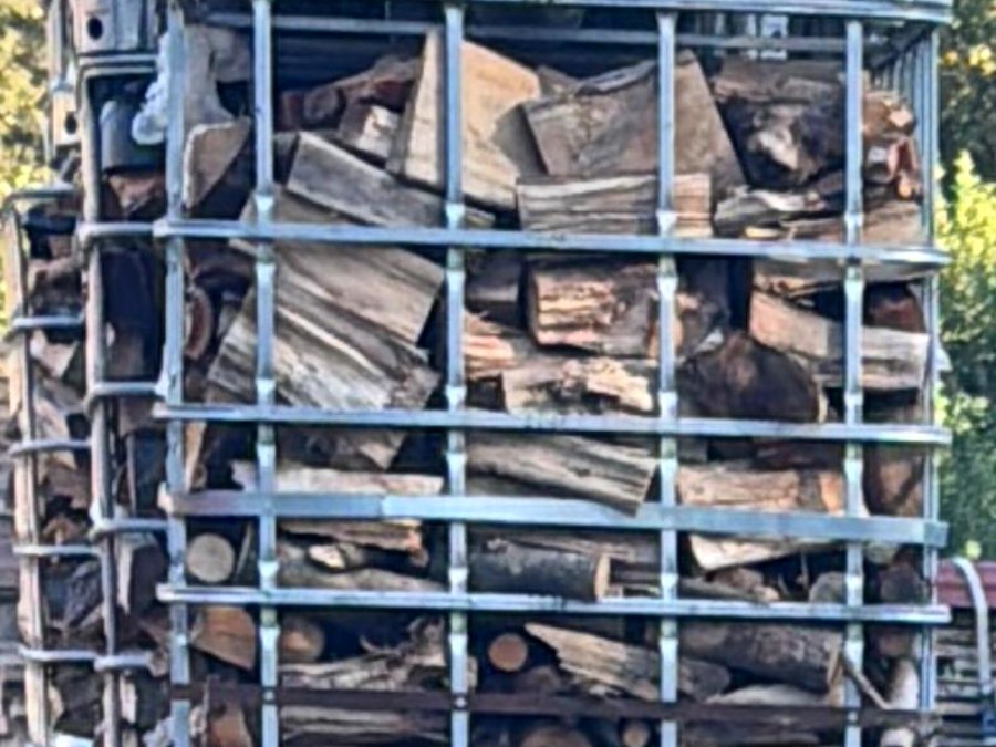 Mit gespaltenem Restholz gefüllte IBC-Gitterkörbe am Holzlagerplatz in Türkenfeld