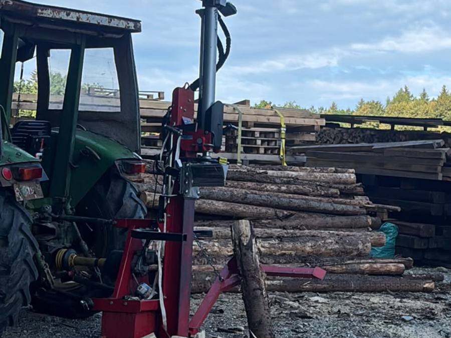 Stehender Holzspalter am Traktor auf dem Lagerplatz bei Türkenfeld, daneben aufgeschichtetes Meterholz