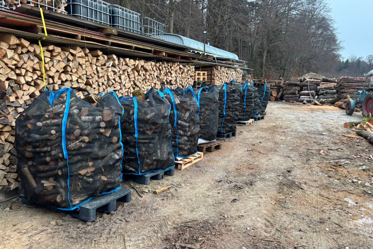 Reihe gefüllter WoodBags auf Paletten vor dem Holzlagerplatz von Raabes Forstservice